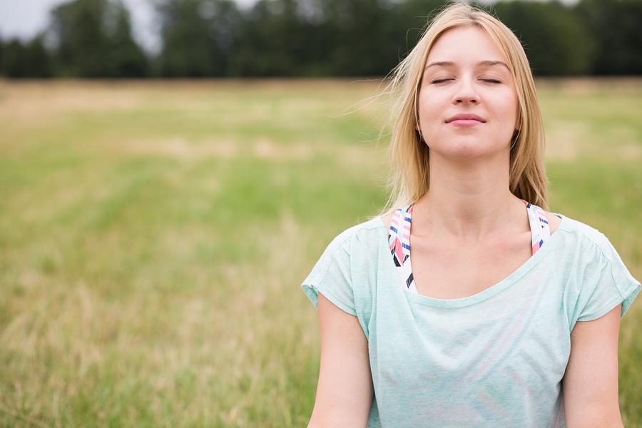 Woman in grass connecting with God