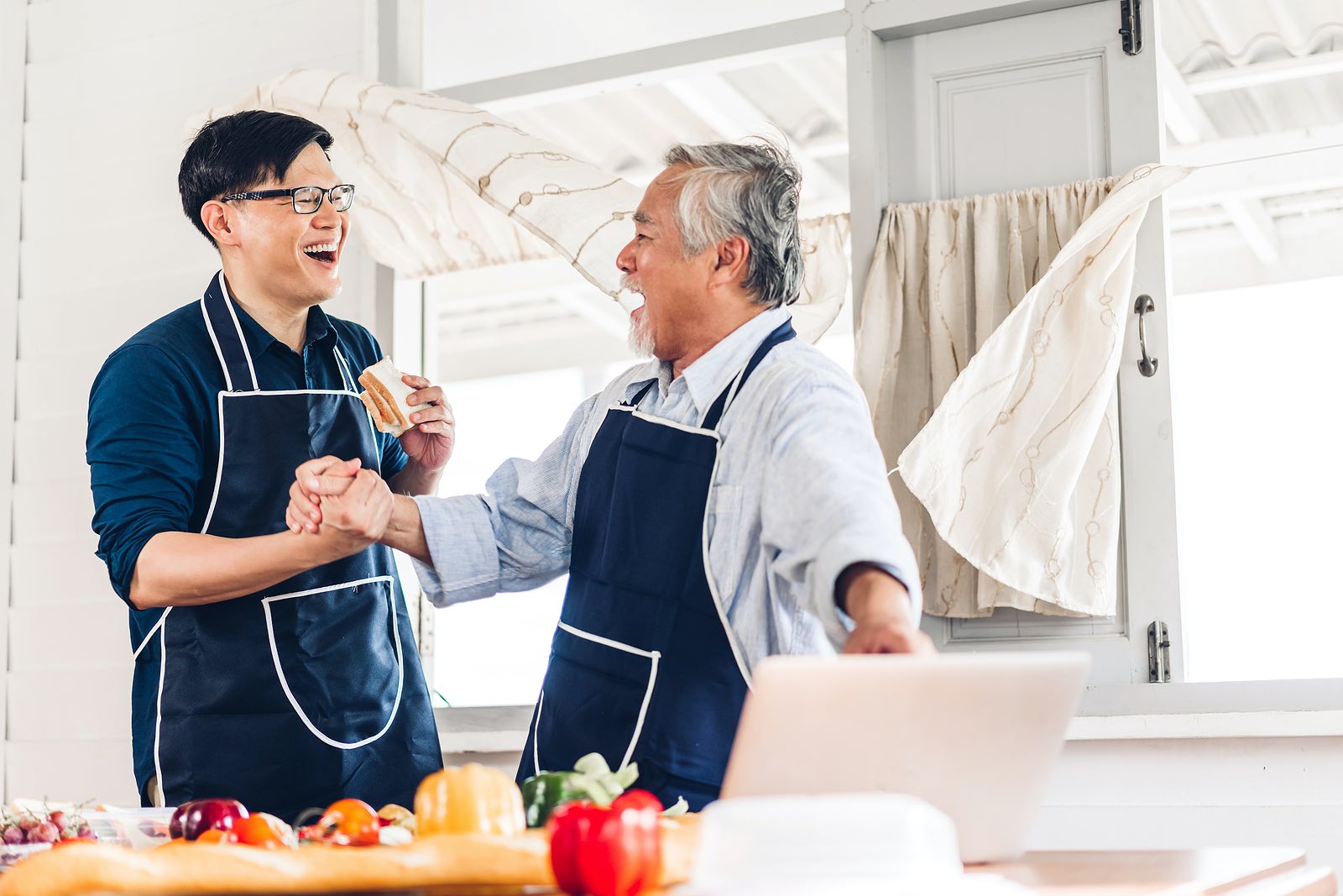 Father and older son laughing in the kitchen